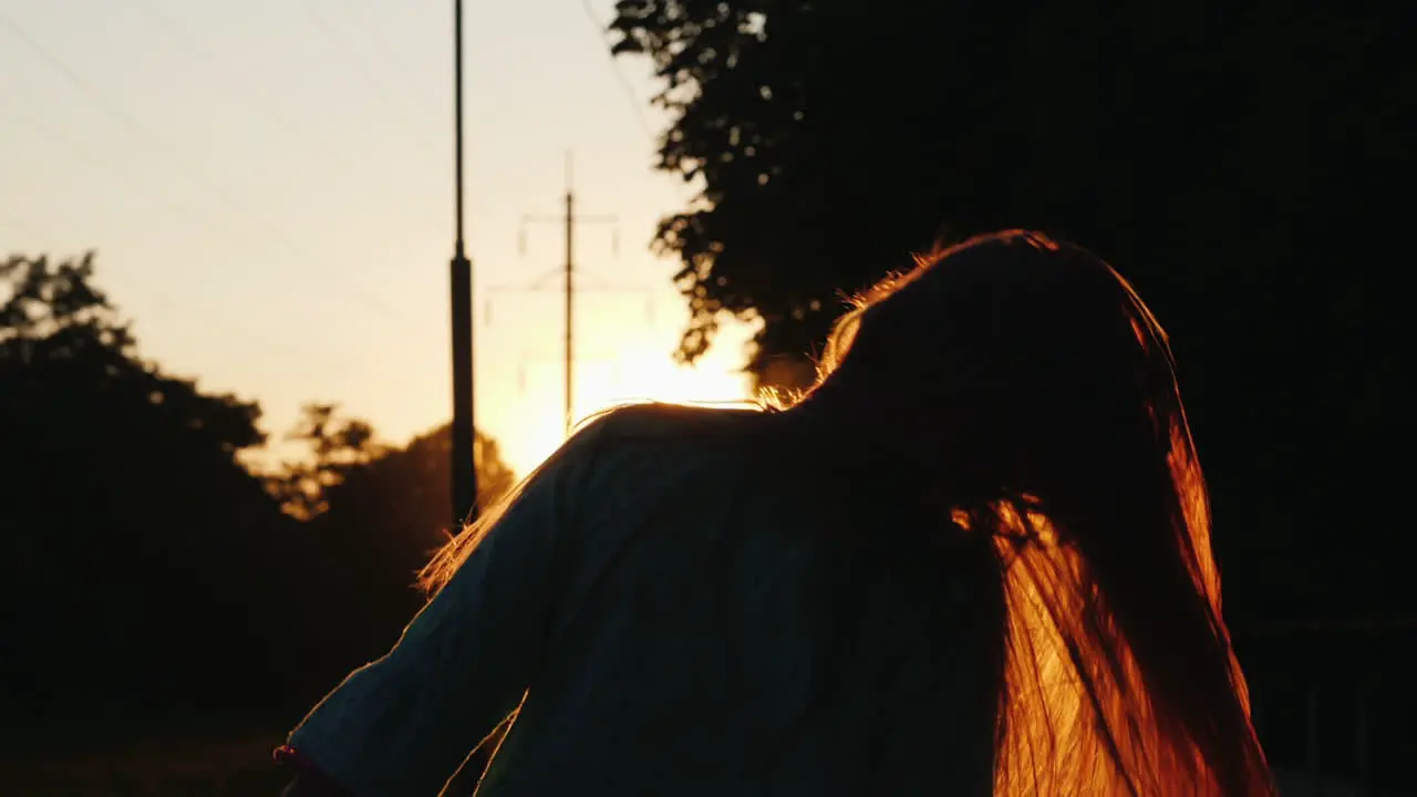 Girl With Long Hair Having Fun At Sunset Waving Her Head Playing With Her Hair In The Sun's Rays