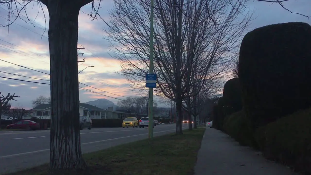 Sunset over neighborhood sidewalk and calm traffic