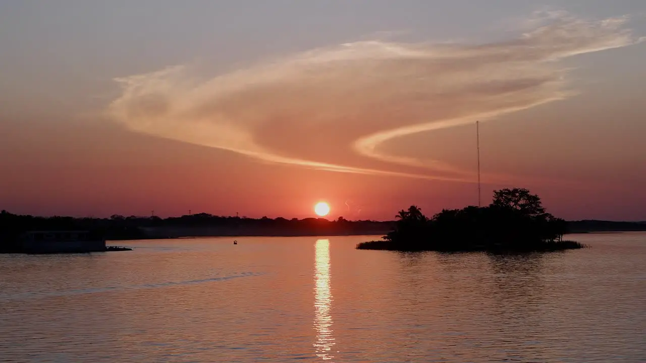 Golden orange sunset reflects on surface of Lago Peten Itza Guatemala