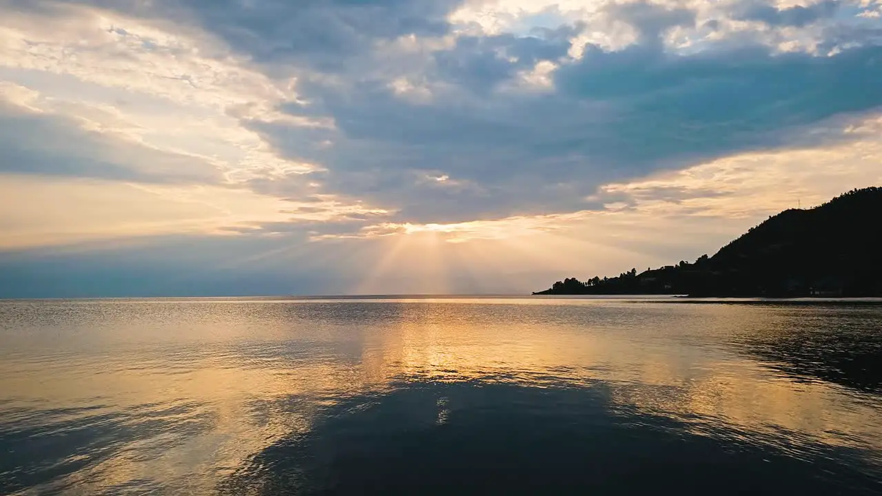 Timelapse of clouds and sunrays over the lake