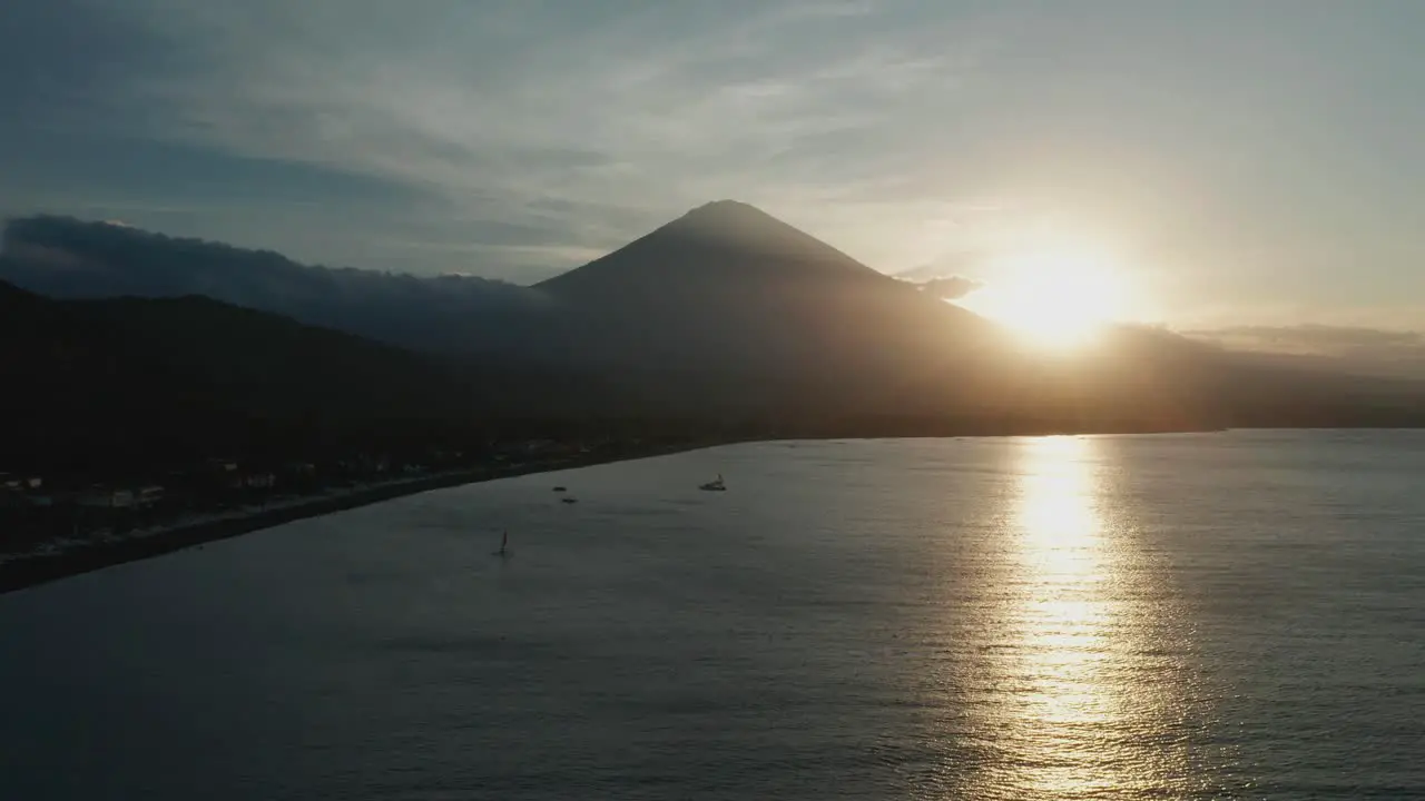 Silhouette of Mount Agung volcano during sunset Bali shore aerial