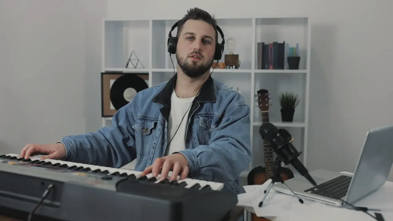 Male Musician Playing Electric Keyboard Looking At Camera At Home