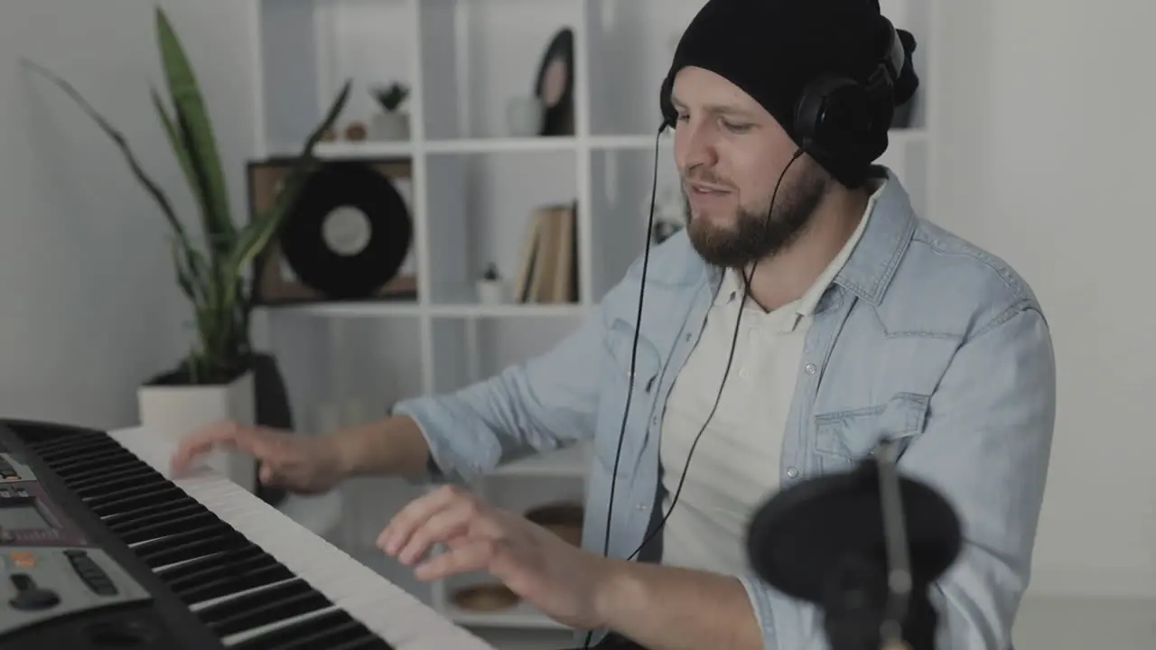 Youn Excited Man Musician Singing And Playing Electric Keyboard At Home