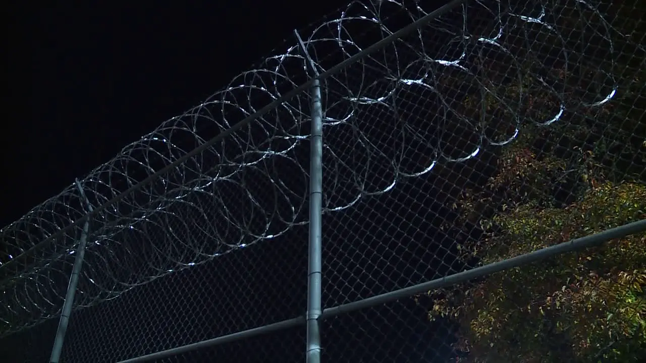 BARB WIRE FENCED JAIL AT NIGHT