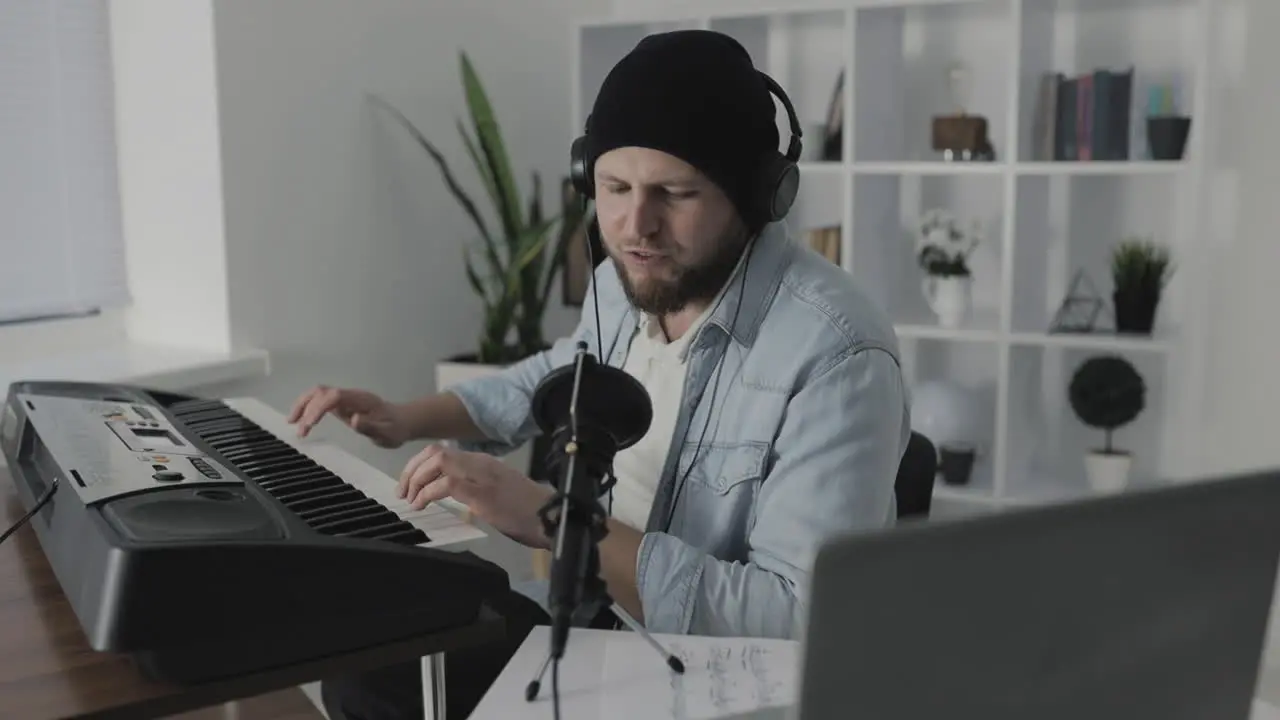 Male Musician Singing And Playing Electric Keyboard At Home 1