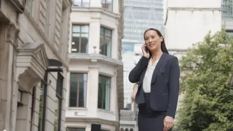 Businesswoman Outside Offices Taking Call On Mobile Phone 2