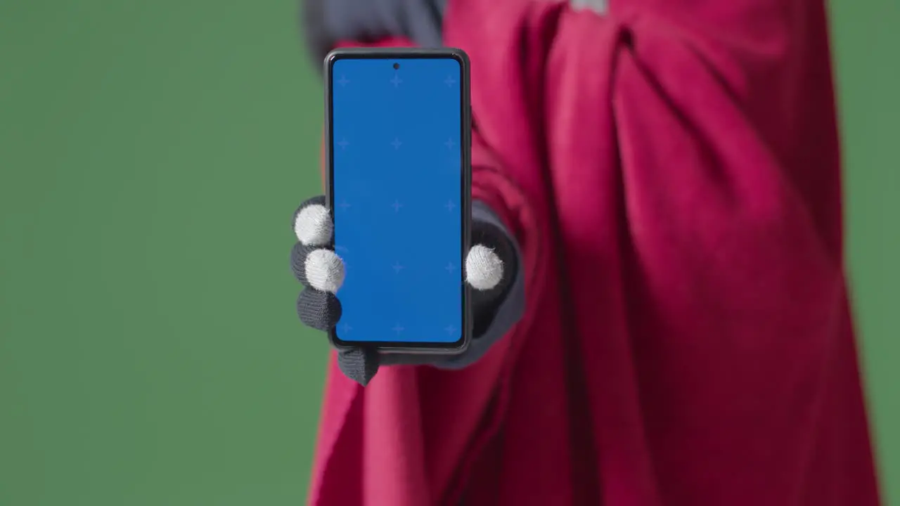 Close Up Of Cold Person Wearing Blanket Holding Blue Screen Mobile Phone Trying To Keep Warm In Energy Crisis 1