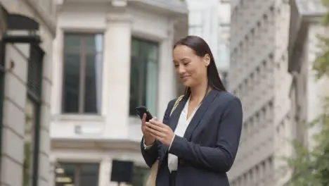 Businesswoman Outside Offices Taking Call On Mobile Phone 1