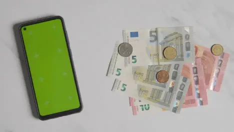 Overhead Currency Shot Person Putting Down Euro Notes And Coins Next To Green Screen Mobile Phone 1