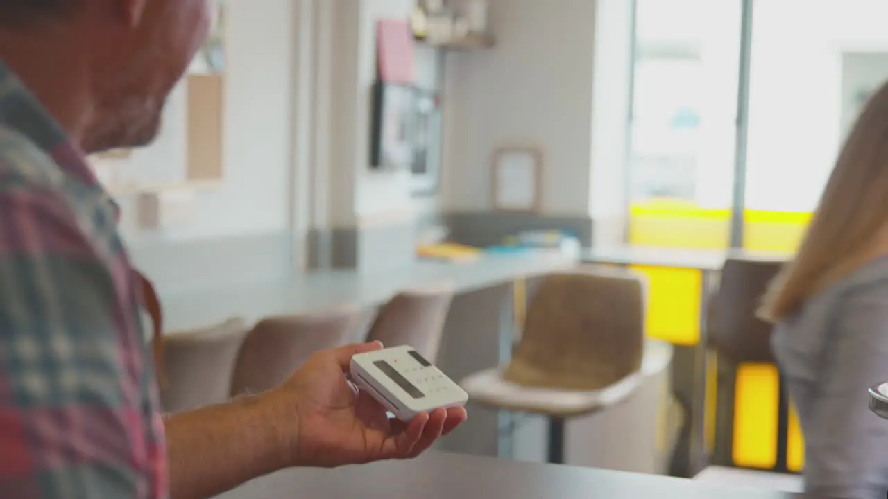 Female Customer Making Contactless Payment For Takeaway Drink In Coffee Shop Using Card