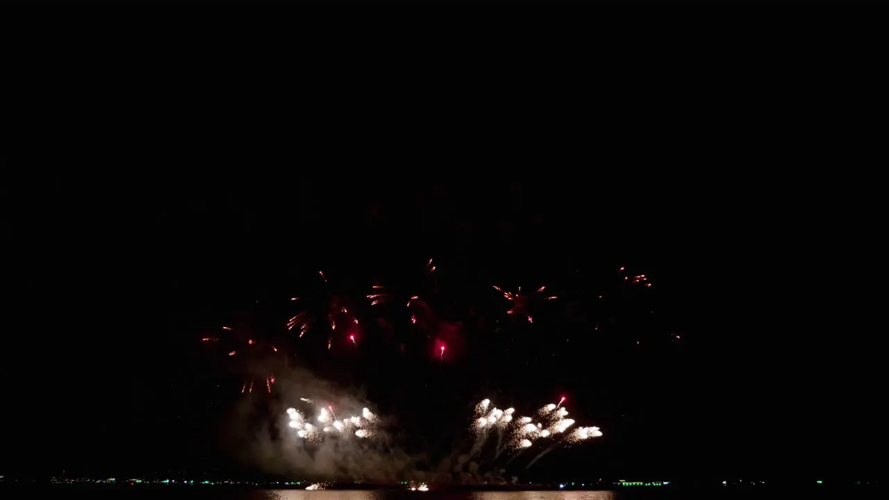 Closer capture of the climaxing fireworks at sea as people watch from the beach Pattaya international Fireworks Festival 2023 Thailand