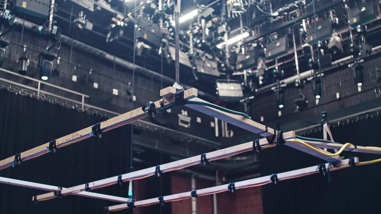 A special effects rain machine in a film cinema studio with a ceiling full of film lights