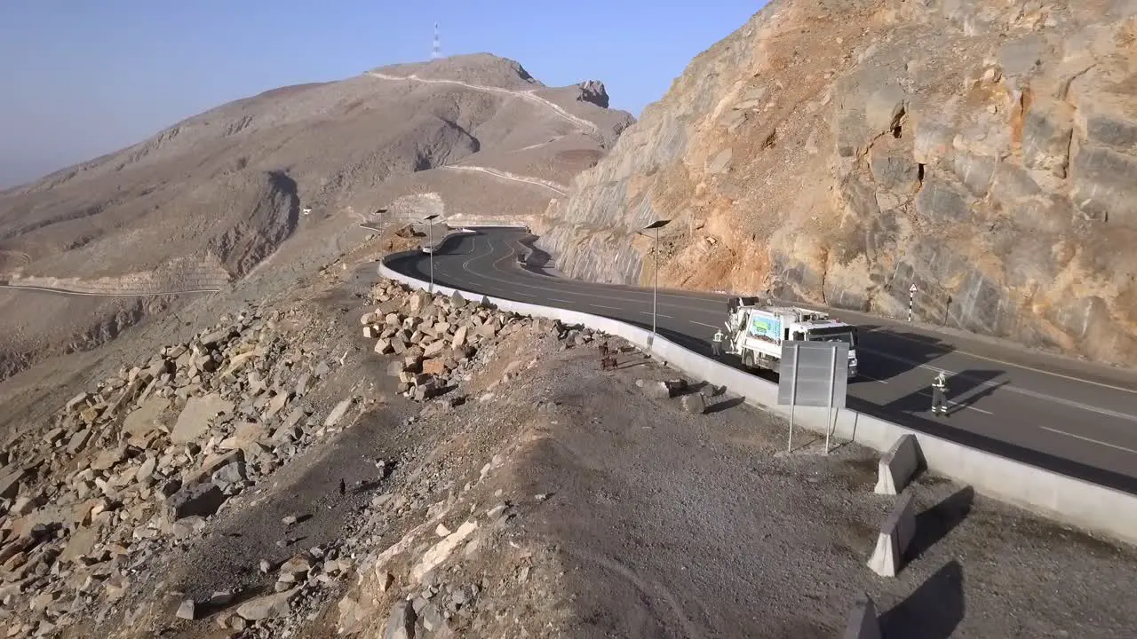 Flying over the road by the Jebel Jais mountainside with tourists enjoying the view Low aerial shot