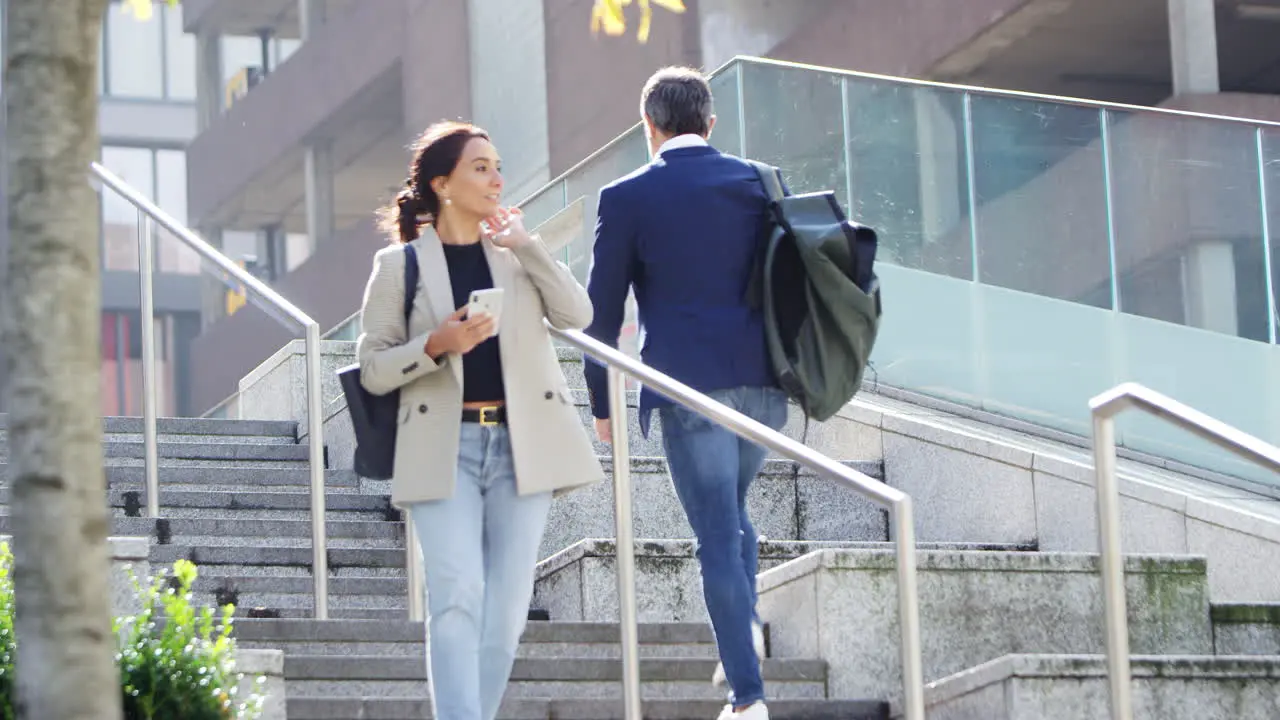 Businessman And Businesswoman Commuting Outdoors Passing On Steps On Way To Work