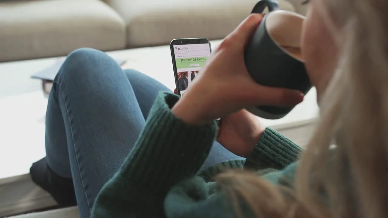 Close Up Of Woman Shopping For Clothes Online Using Mobile Phone App