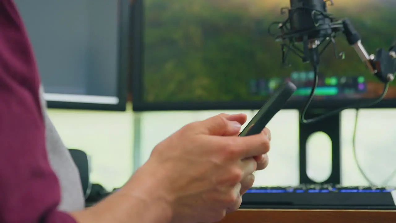 Close up of male vlogger scrolling through mobile phone before live stream- shot in slow motion