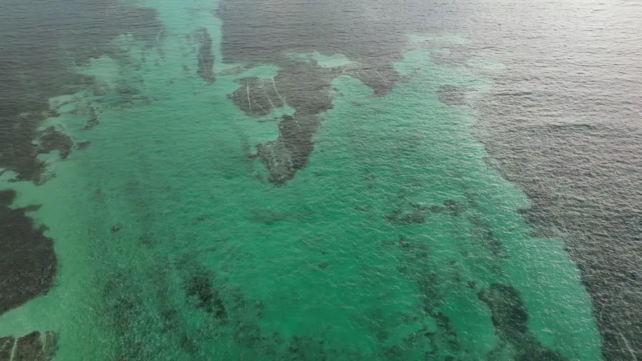 Drone view in Belize flying over caribbean dark and light blue sea top view shallow water coral reef