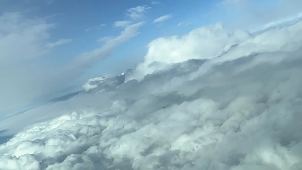 Aerial view from a jet cockpit during a right turn overflying clouds