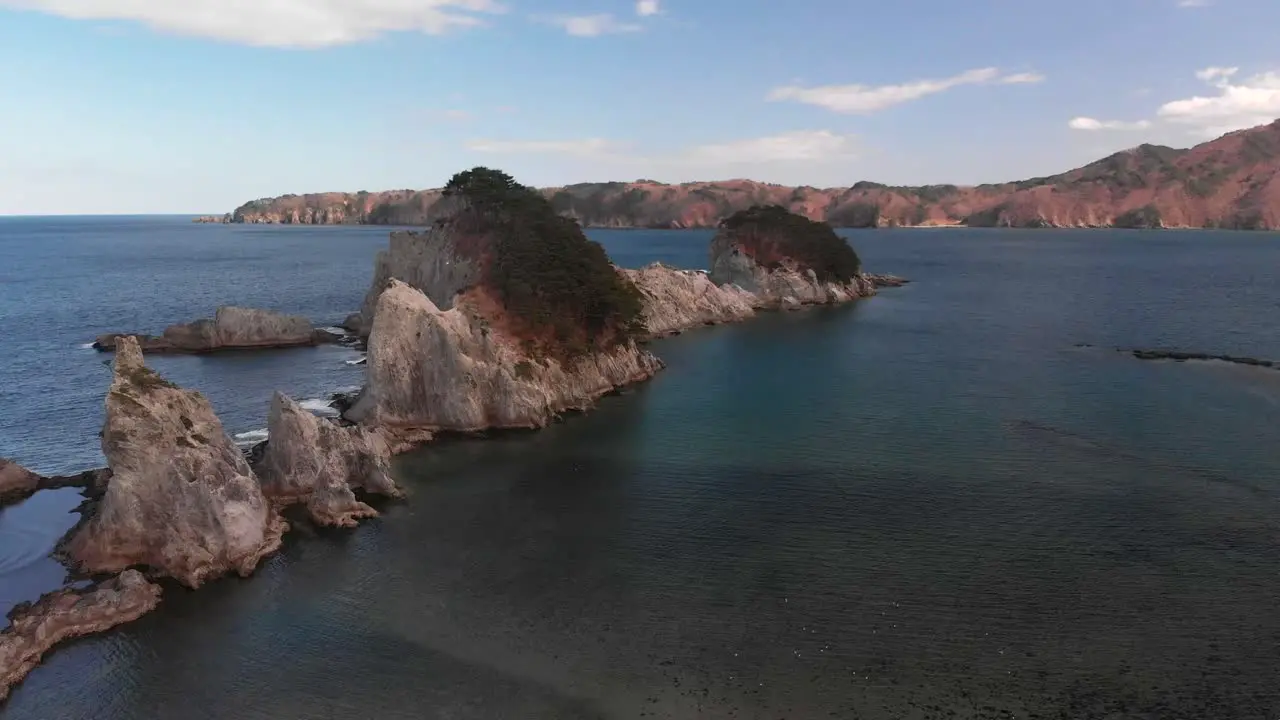 Slow cinematic pull back tilt up over rocky cliffs in beautiful nature ocean