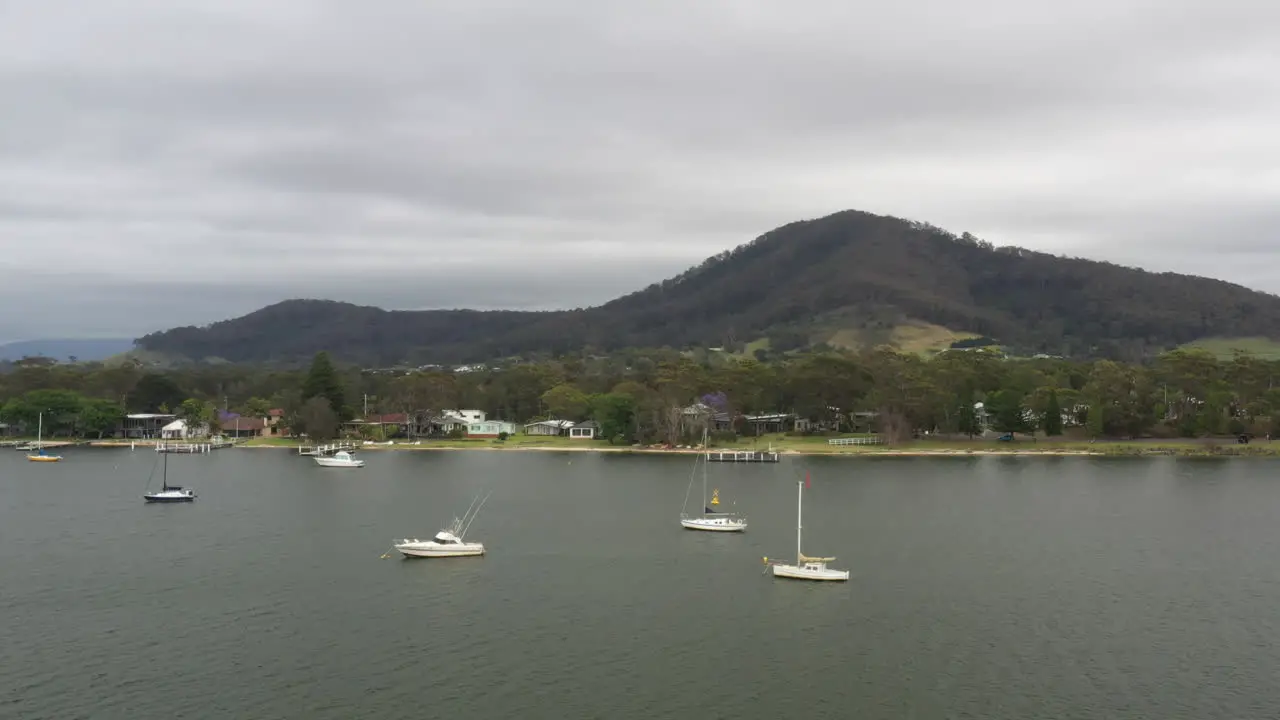 Aerial drone shot around boats moored on the Shoalhaven river near Shoalhaven heads on a stormy day in south coast NSW Australia