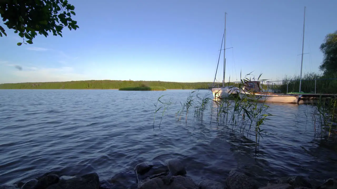 Sailing boats and a small pier on the shore of the large Jezioro Ostrowieckie in Pojezierze Zninskie in summer Poland