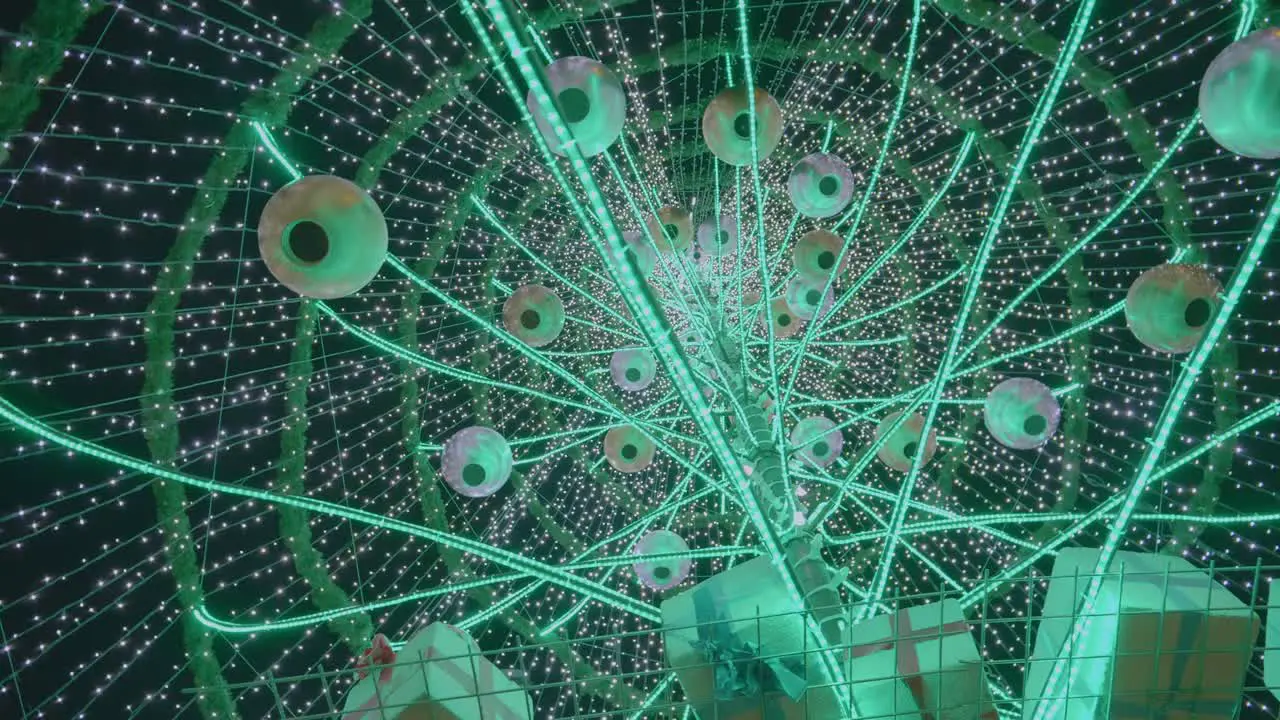 The Above View Of A Giant Christmas Tree With Hanging Round Lanterns Small Gifts And Christmas Lights During Evening Close Up Shot