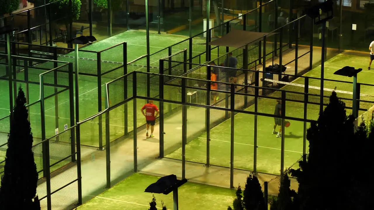 Padel Courts at Night with Players Playing on Lit Sport Fields Static