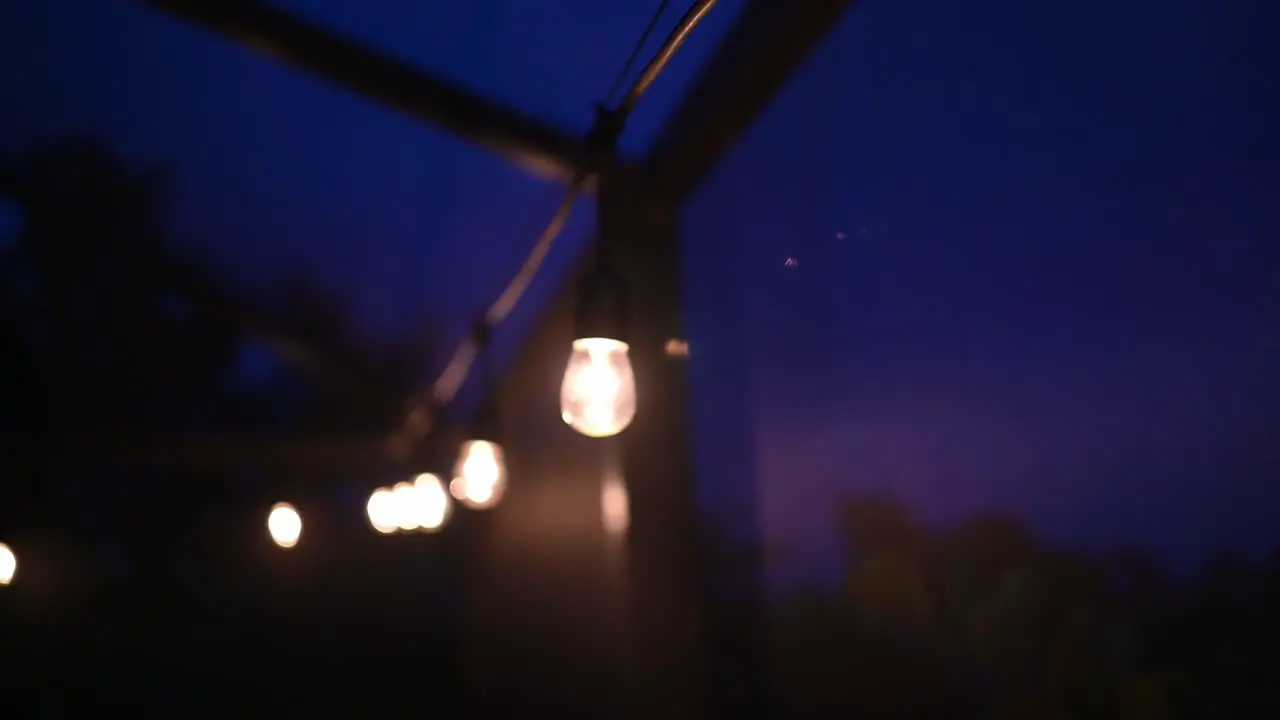 Edison bulb light string at night under a blue sky