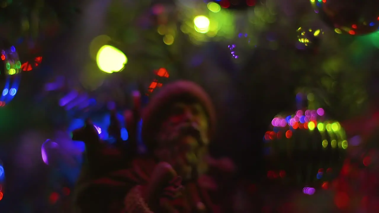 Closeup of classic looking Santa Claus model with multicolored Christmas light bokeh