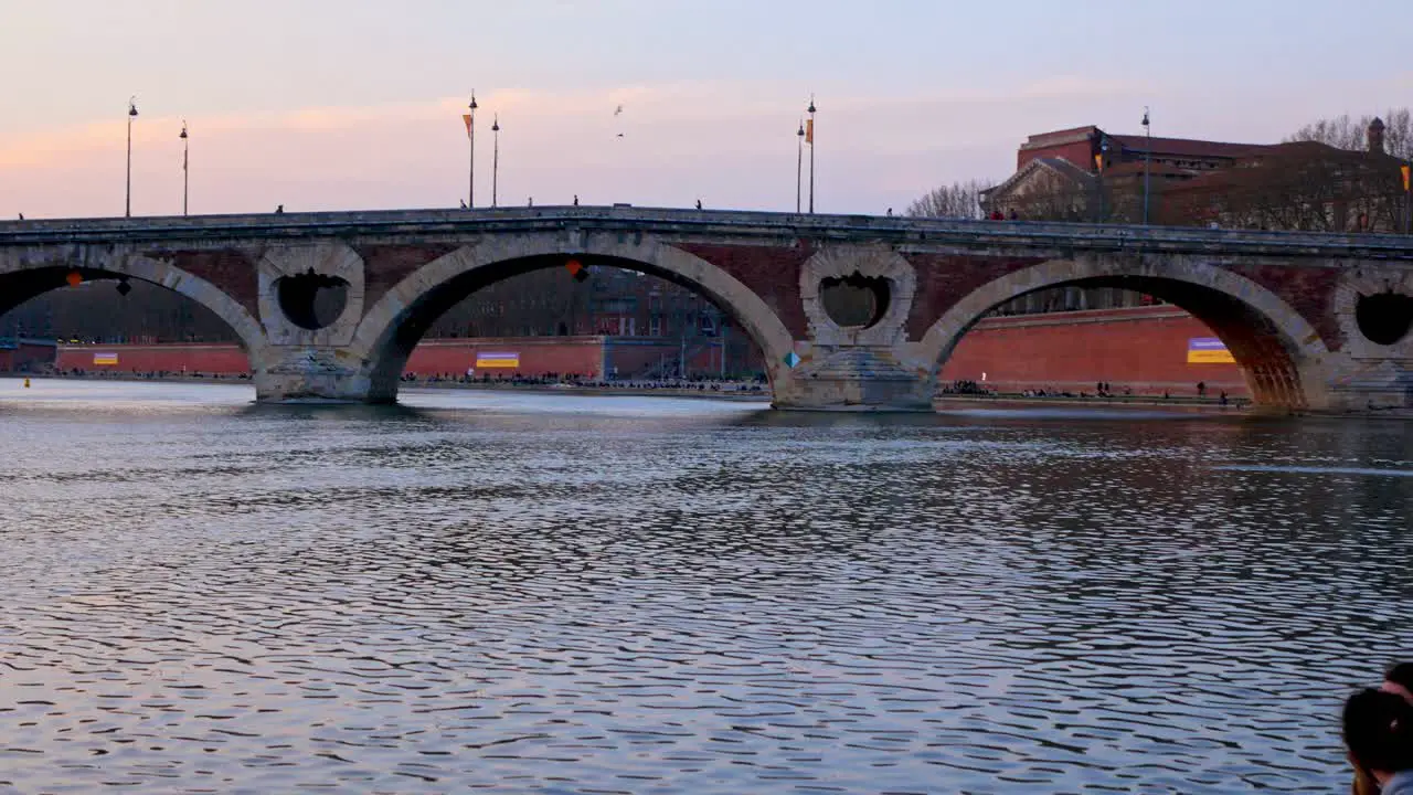 Young couple enjoying sunset in front of "Pont Neuf" in Toulouse France