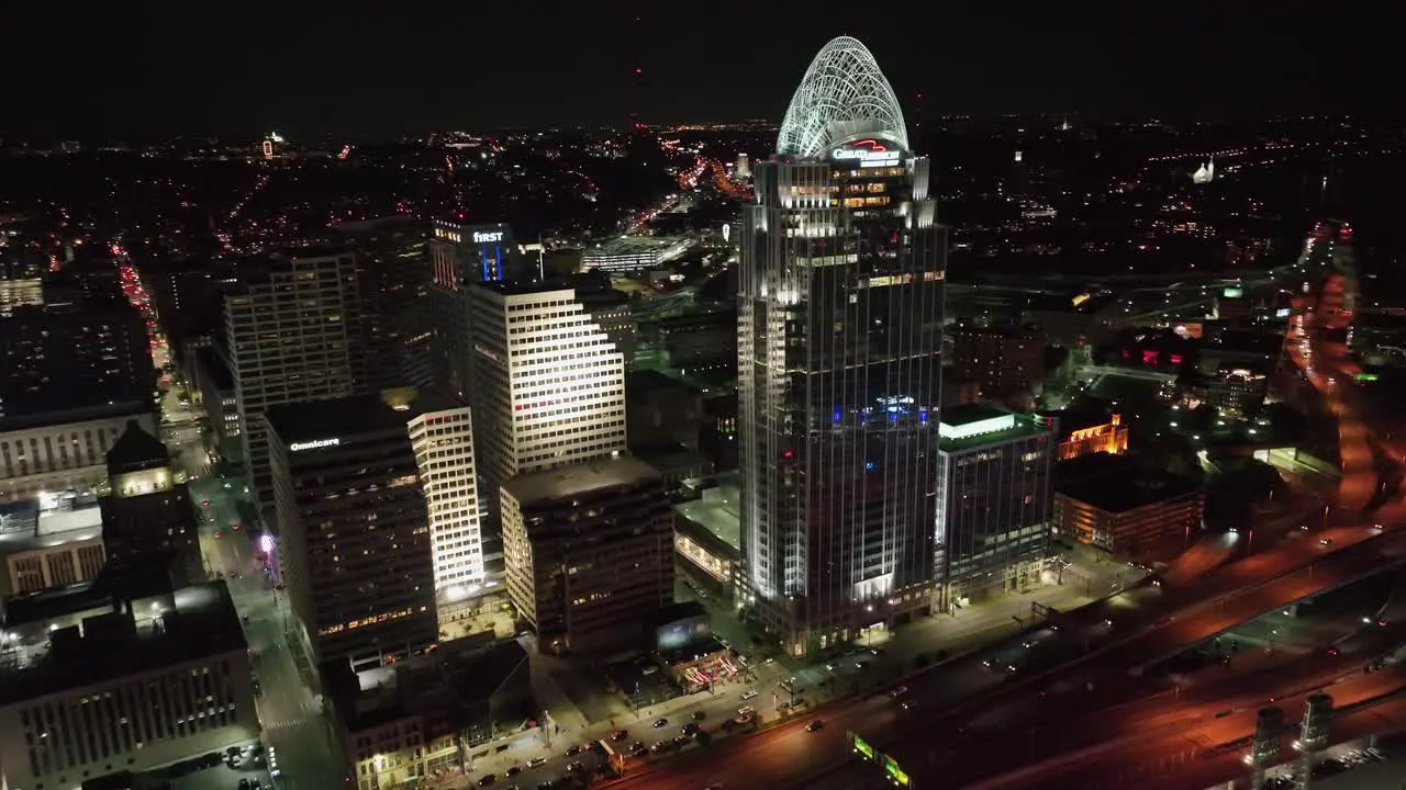 Aerial view in front of the Great American Tower and traffic on Interstate 71 US-50 night in Cincinnati USA reverse tilt drone shot