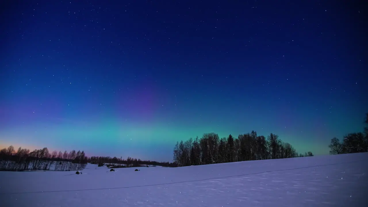 Shimmering glow of the aurora borealis over a northern winter wilderness time lapse