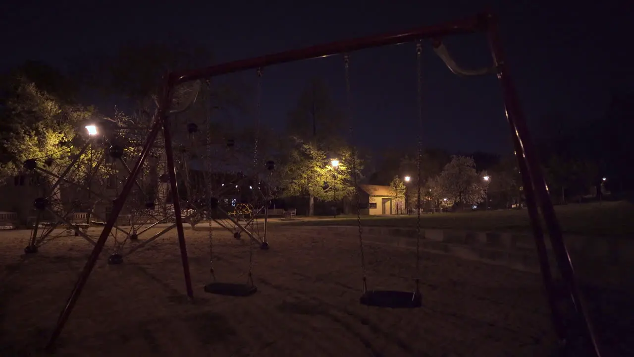 Swings climbing bars empty playground at night Prague Czechia during lockdown