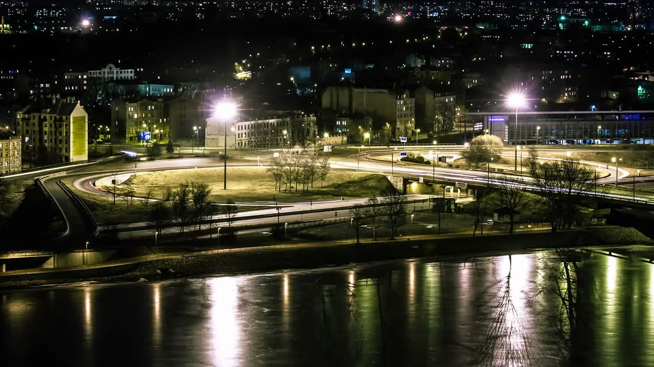 Timelapse Of Traffic Driving In The City At Night With Light Reflection Of The River