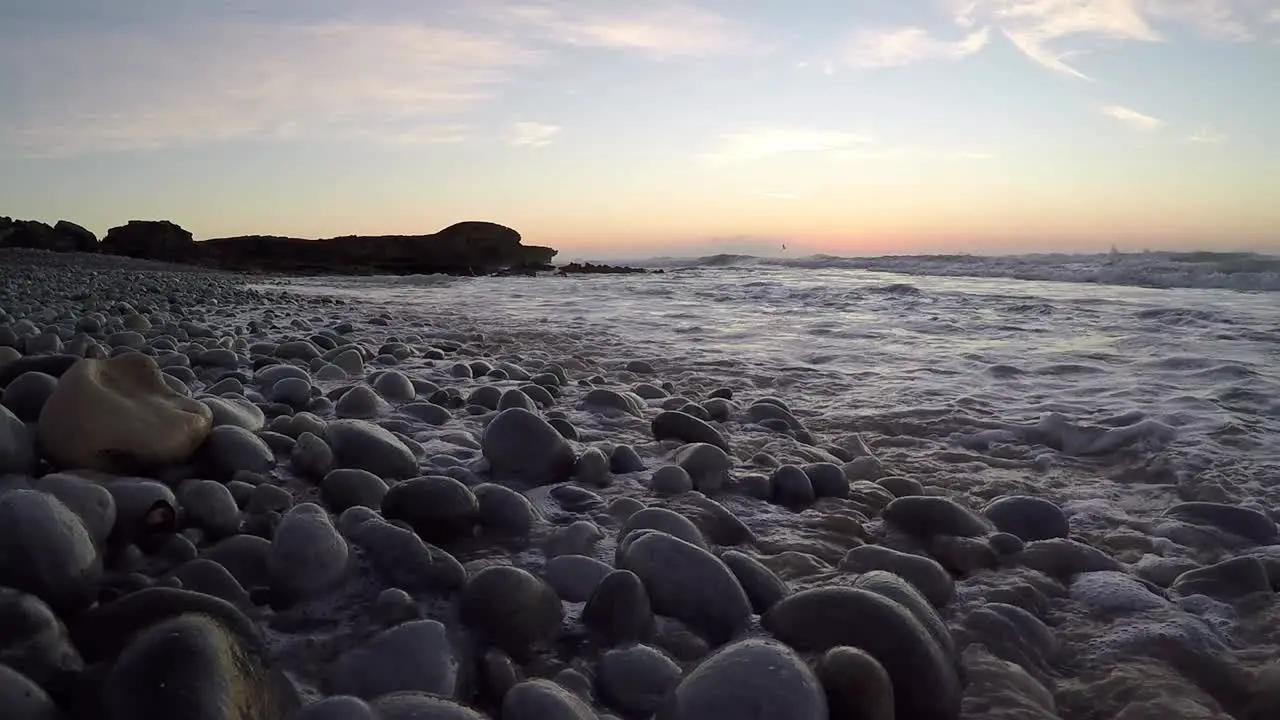 Early morning waves breaking onto pebble beach