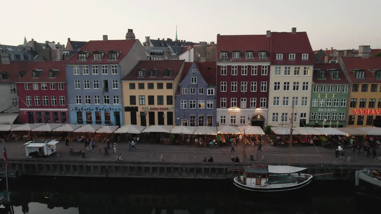 Sunset over Nyhavn in Copenhagen with a cozy atmosphere people and ships in the canal