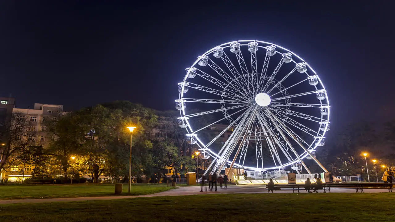 Huge Christmas illuminated wheel for people with a beautiful view of Moravian Square in Brno moving during a cold evening during the time lapse video dominates the Christmas preparations in city