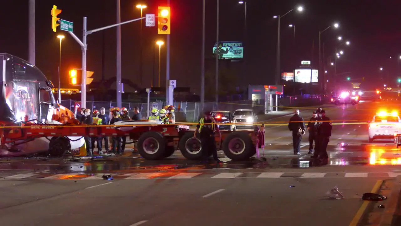 Firefighters and Police at Accident Scene of Car Lodged in Flatbed Truck after High Speed Crash Brampton Ontario Canada Wide Panning Shot