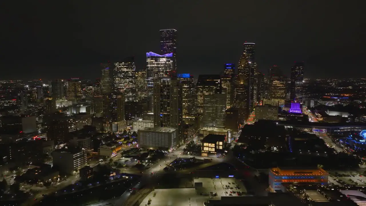 Aerial view around the cityscape of downtown Houston during nighttime in Texas USA wide panoramic drone shot