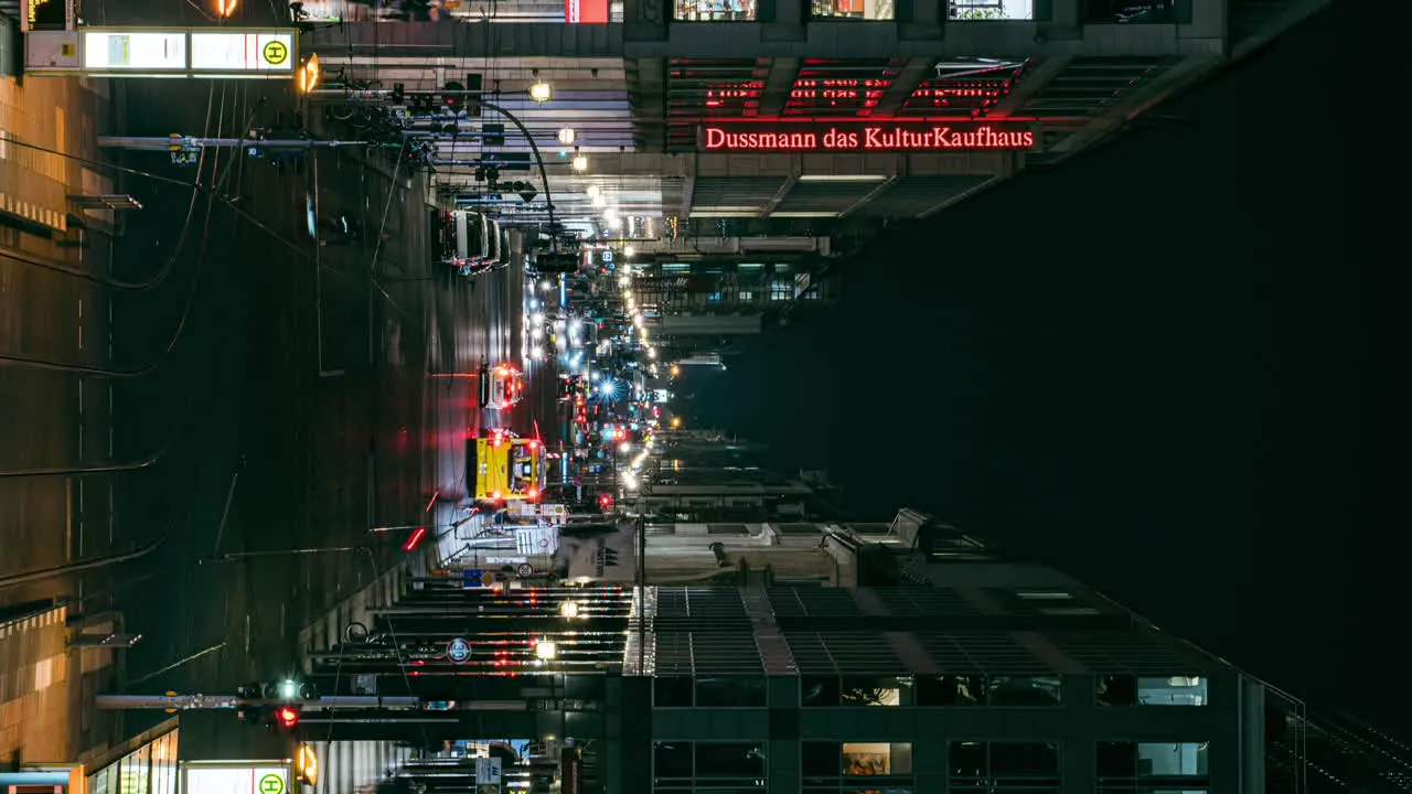 VERTICAL busy city centre avenue Friedrichstrasse illuminated at night in Berlin time lapse