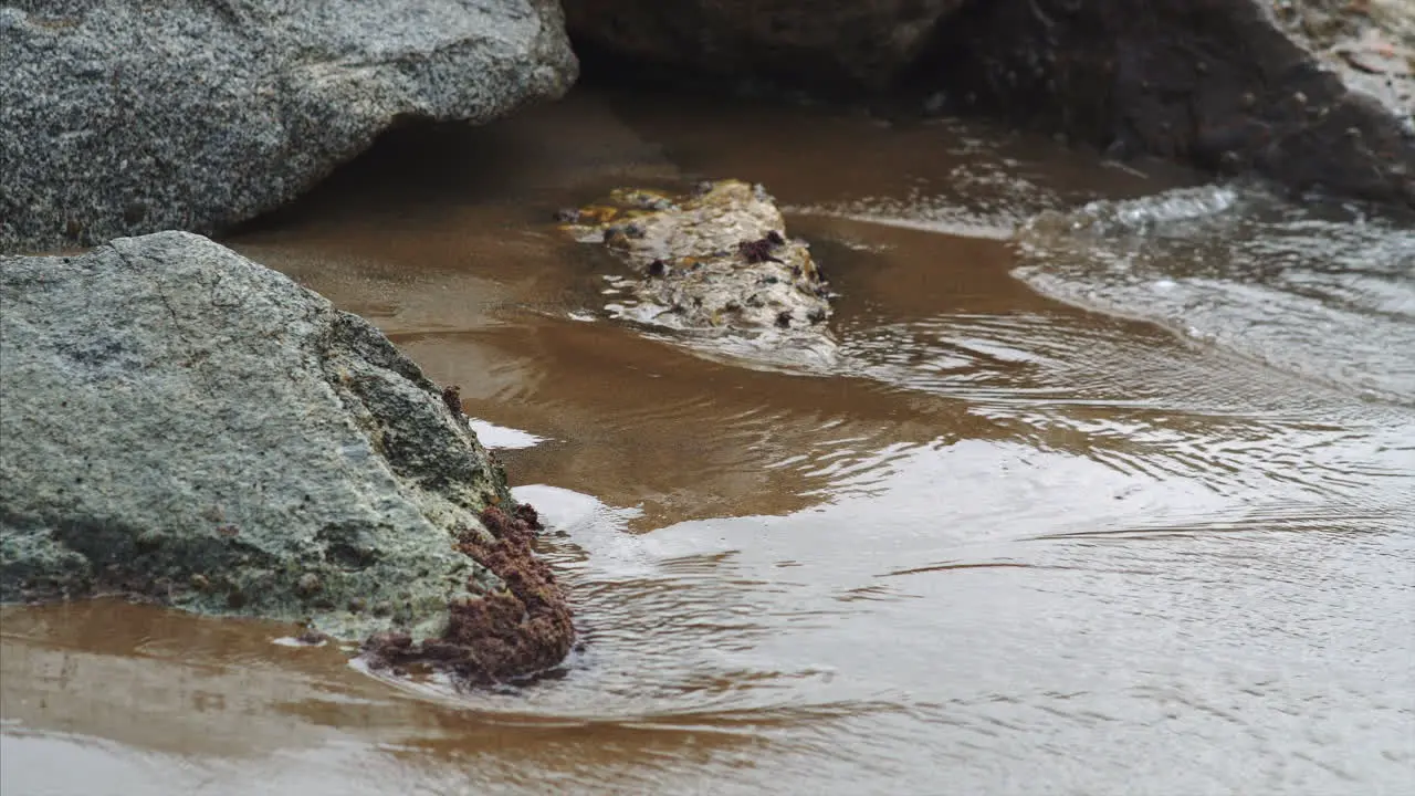 Waves crashing on rocks with a sandy beach