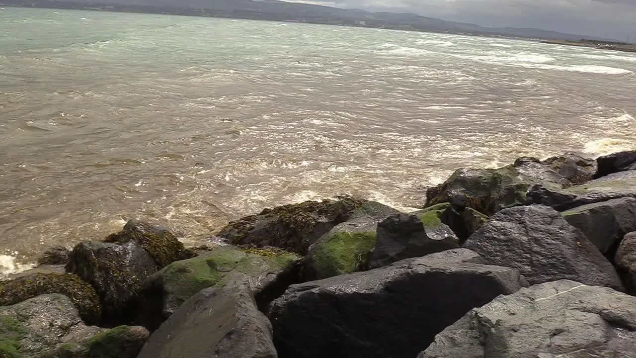 Waves crash against rocks in Dublin Citys south wall