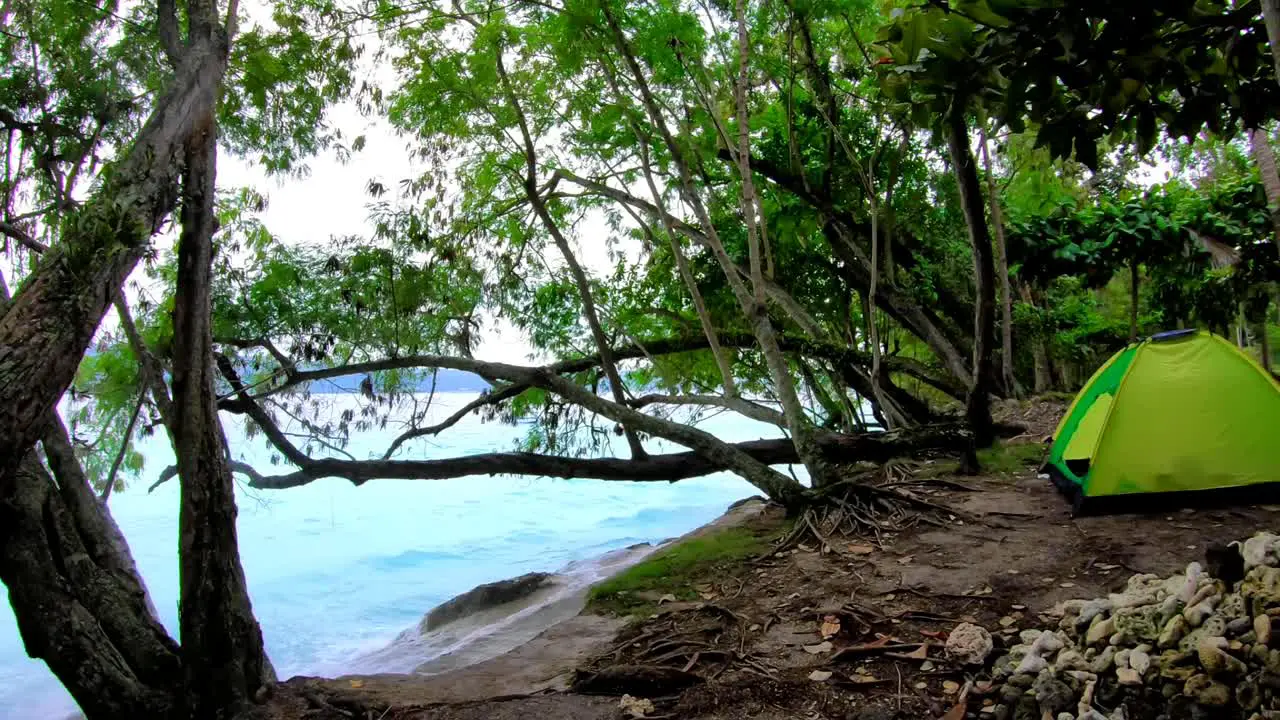 a tent uphill with a view of blue waters splashes the pile rocks