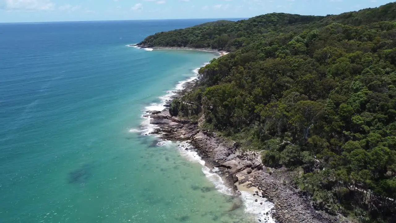 Flying over rocky coastline towards a peninsula