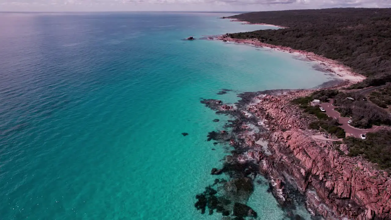 Aerial fly along the coast of the crystal clear turquoise waters and orange rocks of castle rock Western Australia