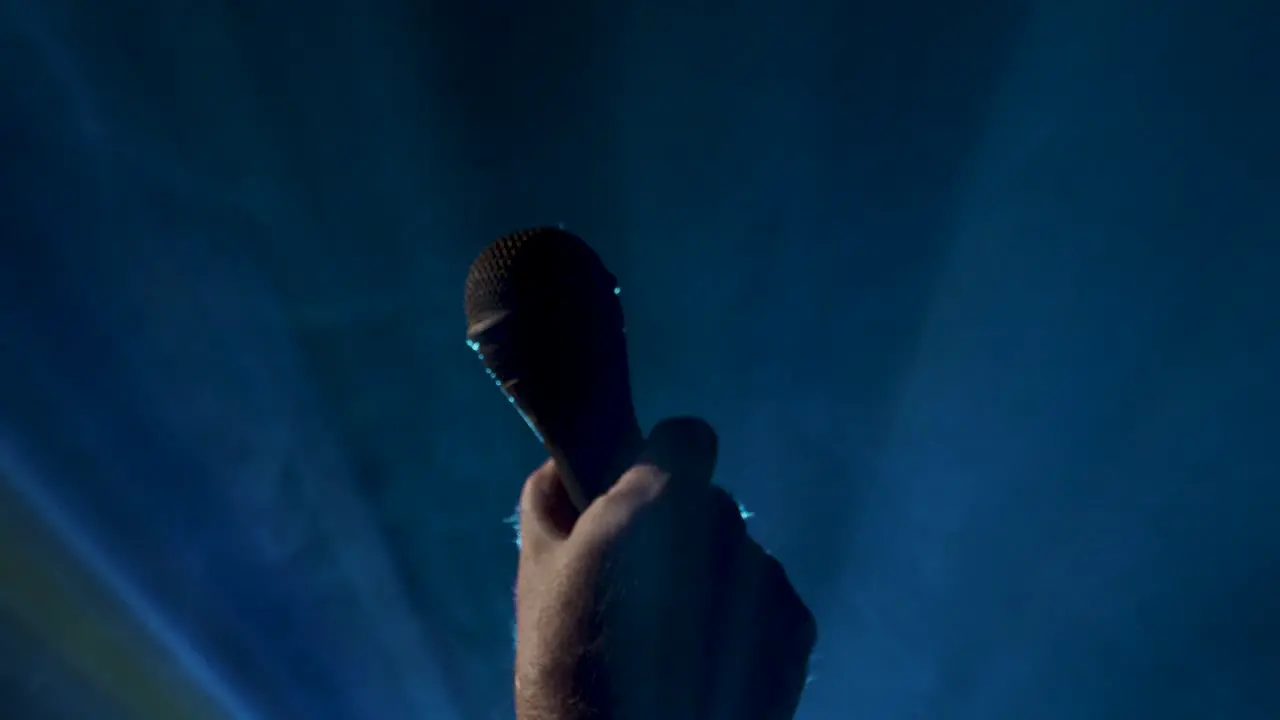 Microphone rises into a shot on a smokey background