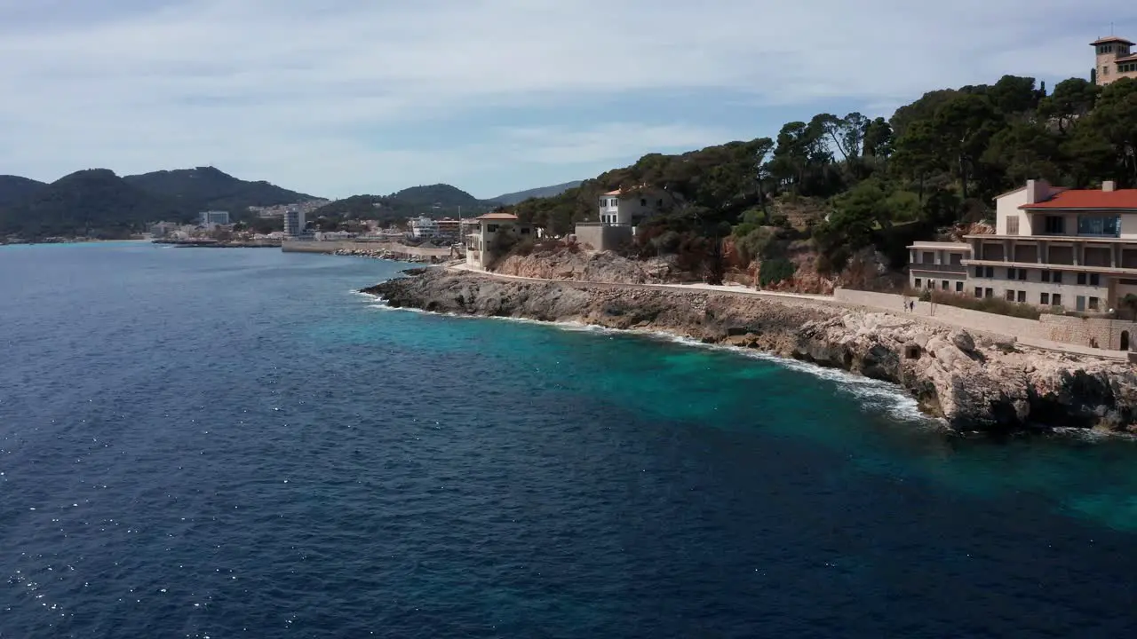 Drone Shot Cala Rajada Harbour in Mallorca with clear blue water with mountains and hills in the background