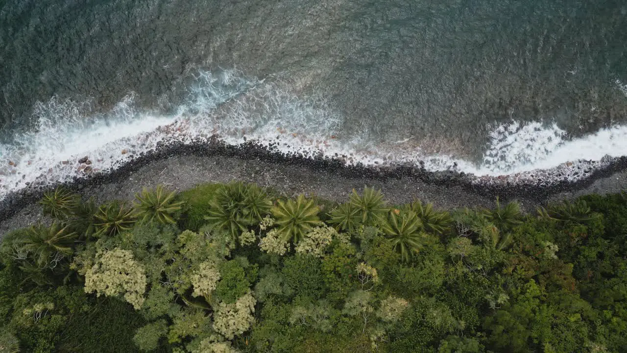 Aerial Top Down Tracking Shot Along Rocky Coastline With Waves Breaking Off Kalaloa Point