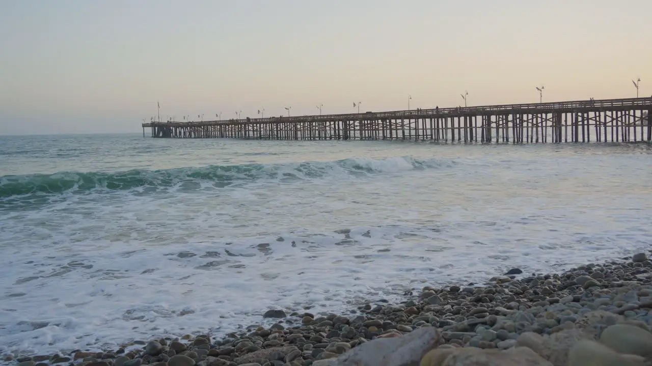 Panning shot of waves crashing along the shores of Ventura Beach located in Southern California