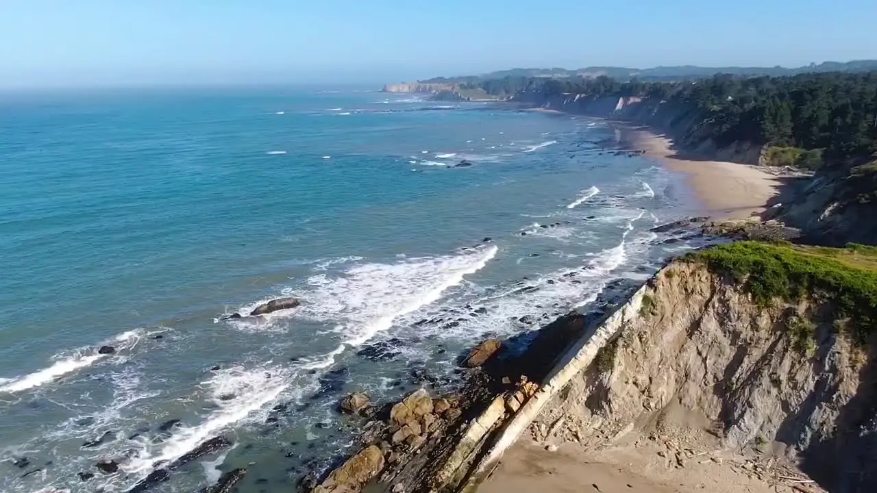 Drone video capturing the beauty of a beach landscape with cliffs meeting the ocean waves in Bodega Bay Gualala Coast